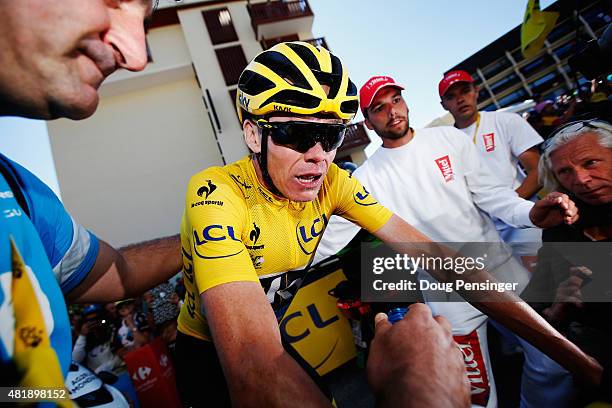 Chris Froome of Great Britain and Team Sky is surrounded by team mates and media as he crosses the finish line at the end of the twentieth stage of...