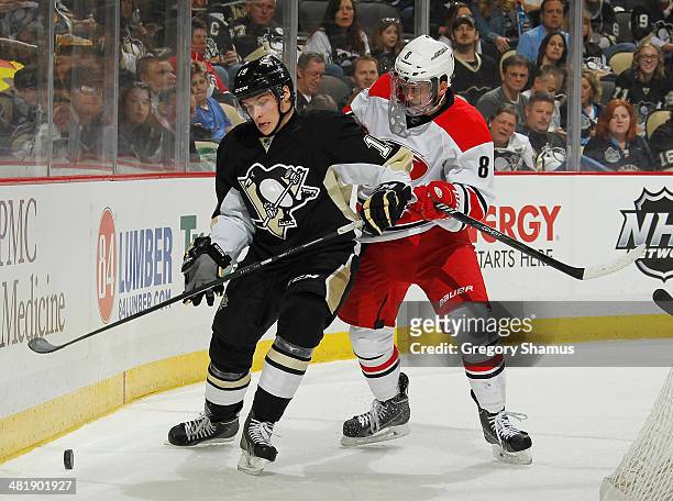 Beau Bennett of the Pittsburgh Penguins battles for the loose puck against Andrei Loktionov of the Carolina Hurricanes on April 1, 2014 at Consol...