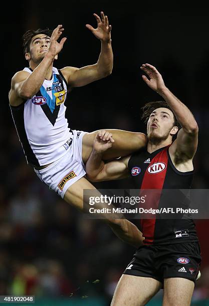 Chad Wingard of the Power leaps for a high mark attempt over Michael Hibberd of the Bombers during the round 17 AFL match between the Essendon...