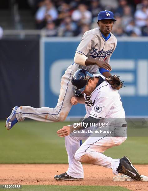 Dee Gordon of the Los Angeles Dodgers goes over Seth Smith of the San Diego Padres as he turns a double play during the sixth inning of a baseball...