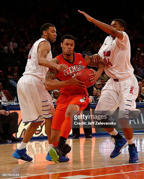 McDaniels of the Clemson Tigers drives by Ben Moore of the Southern Methodist Mustangs during the NIT Championship semifinals at Madison Square...