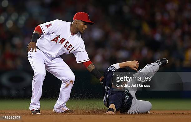 Justin Smoak of the Seattle Mariners is tagged out by shortstop Erick Aybar of the Los Angeles Angels of Anaheim during a steal attempt in the second...
