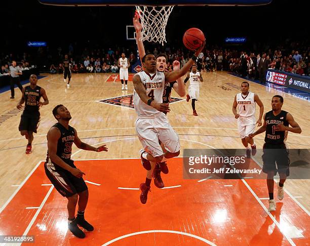 Deandre Mathieu of the Minnesota Golden Gophers drives by Boris Bojanovsky of the Florida State Seminoles during the NIT Championship semifinals at...