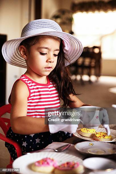 schöne hispanische afroamerikanische mädchen mit einem tee-party - cupcake teacup stock-fotos und bilder