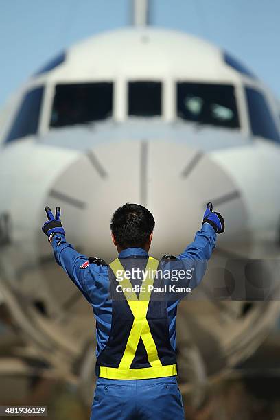 Ground crew member from the Japanese Maritime Self Defence Force signals to a P3 Orion pilot for engine startup at RAAF base Pearce on April 2, 2014...