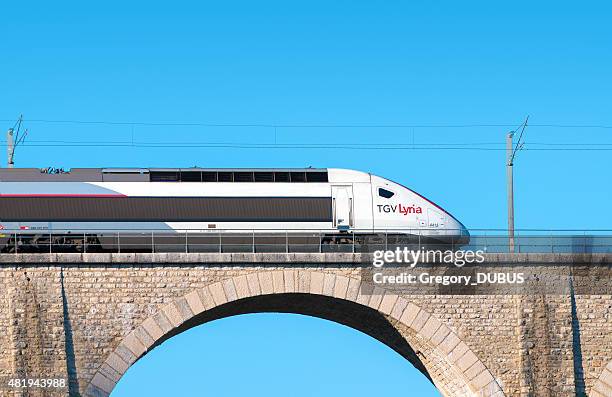 franco swiss tgv lyria high speed train on stone bridge - 阿爾斯通公司 個照片及圖片檔