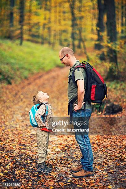 father and son hiking in autumn beech forest - large rucksack stock pictures, royalty-free photos & images