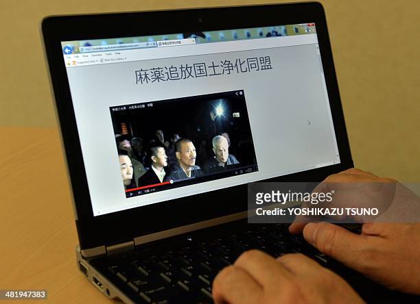 In this photo illustration a man uses a laptop to browse a home page of the "Banish Drugs and Purify the Nation League" website displaying a video...