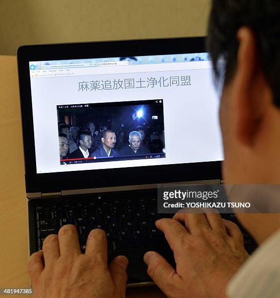 In this photo illustration a man uses a laptop to browse a home page of the "Banish Drugs and Purify the Nation League" website displaying a video...