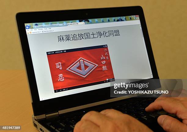 In this photo illustration a man uses a laptop to browse a home page of the "Banish Drugs and Purify the Nation League" website displaying a video...