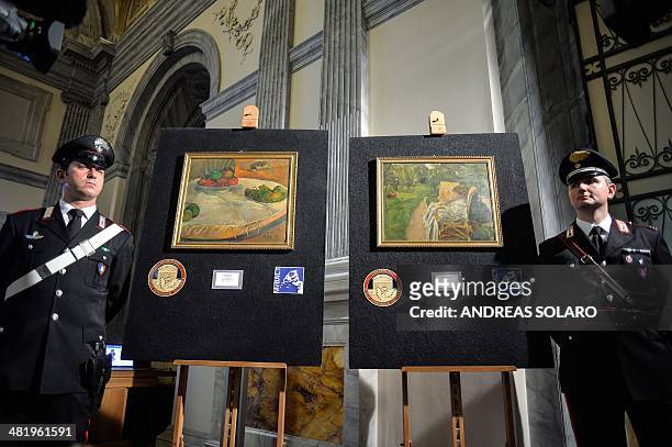 Carabinieri stand next to the two paintings stolen in London in the 1970s by French artists Paul Gauguin "Fruits sur une table ou nature morte au...