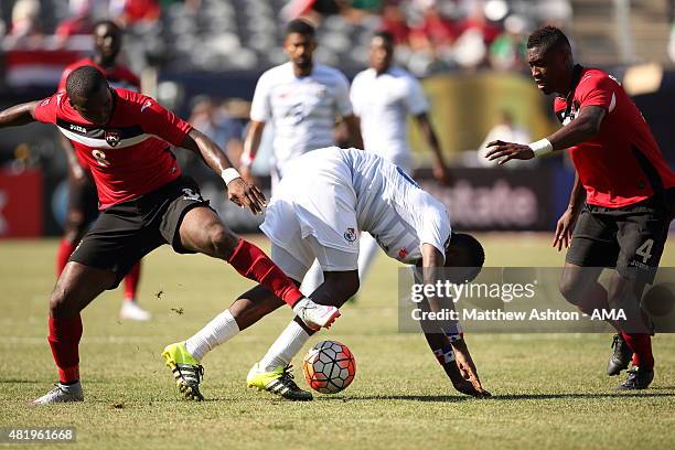 Khaleem Hyland and Sheldon Bateau of Trinidad and Tobago tackle Luis Tejada of Panama during the Gold Cup Quarter Final between Trinidad & Tobago and...