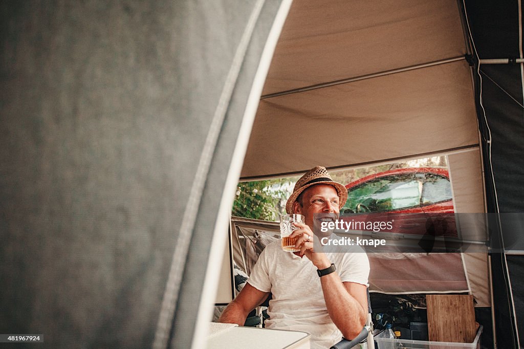 Happy an camping in his caravan at camping