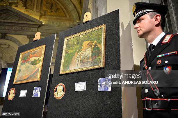 Carabinieri stands next to the two paintings stolen in London in the 1970s by French artists Paul Gauguin "Fruits sur une table ou nature morte au...