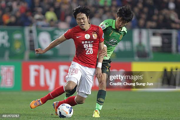 Kim Young-Gwon of Guangzhou Evergrande compete for the ball with Han Kyo-Won of Jeonbuk Hyundai Motors during the AFC Champions League Group G match...