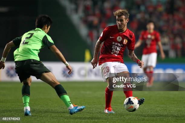 Alessandro Diamanti of Guangzhou Evergrande passes the ball in front of Lee Kyu-Ro of Jeonbuk Hyundai Motors battle for the ball during the AFC...