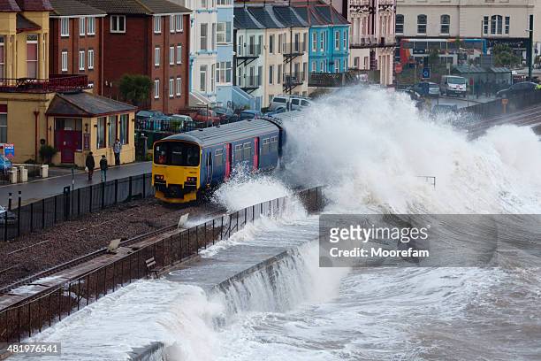 local train passing dawlish station during severe storm - storm damage stock pictures, royalty-free photos & images