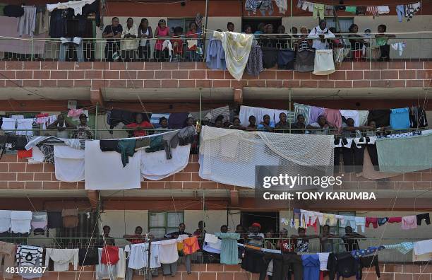 Residents gather on the balconies of an apartment block near the scene where an improvised explosive device, IED, had been set on April 2, 2014 in...