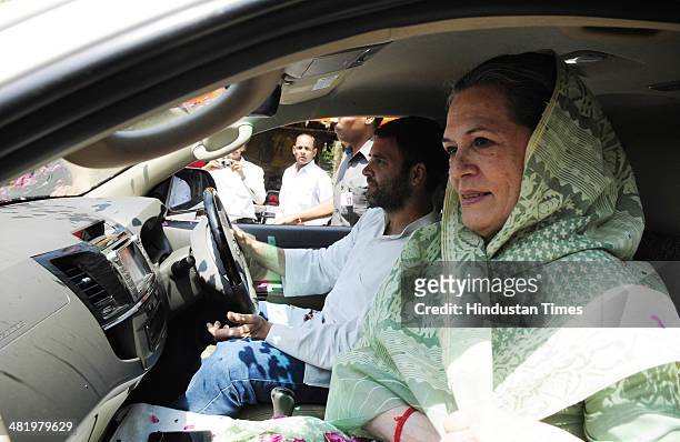 Chairperson and Congress President Sonia Gandhi accompanied by her son and Congress Vice-President Rahul Gandhi driving the car goes to file her...