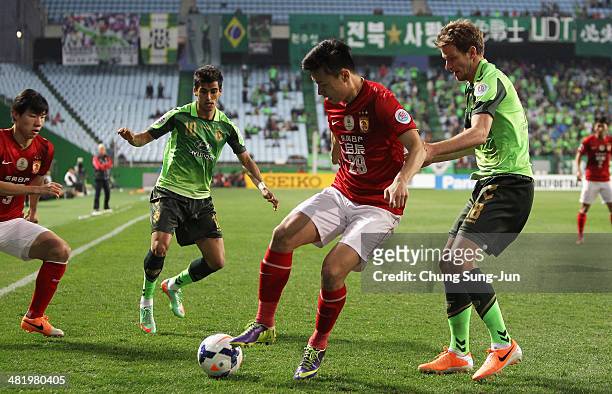 Gao Lin of Guangzhou Evergrande compete for the ball with Leonardo and Alex Wilkinson of Jeonbuk Hyundai Motors during the AFC Champions League Group...