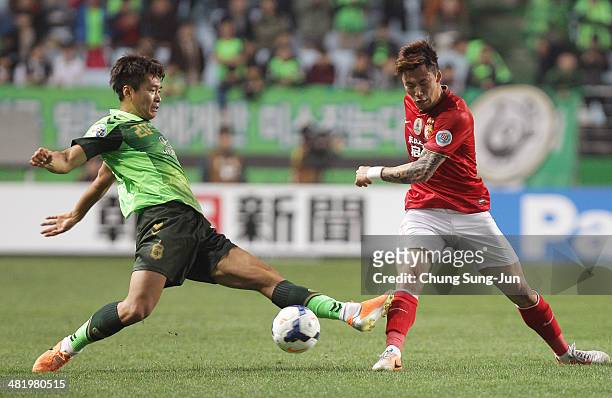 Zhang Linpeng of Guangzhou Evergrande competes for the ball with Lee Dong-Gook of Jeonbuk Hyundai Motors during the AFC Champions League Group G...