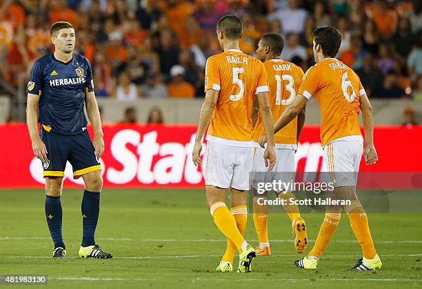 Steven Gerrard of the Los Angeles Galaxy waits in front of Raul Rodriguez, Ricardo Clark and Nathan Sturgis of Houston Dynamo at BBVA Compass Stadium...