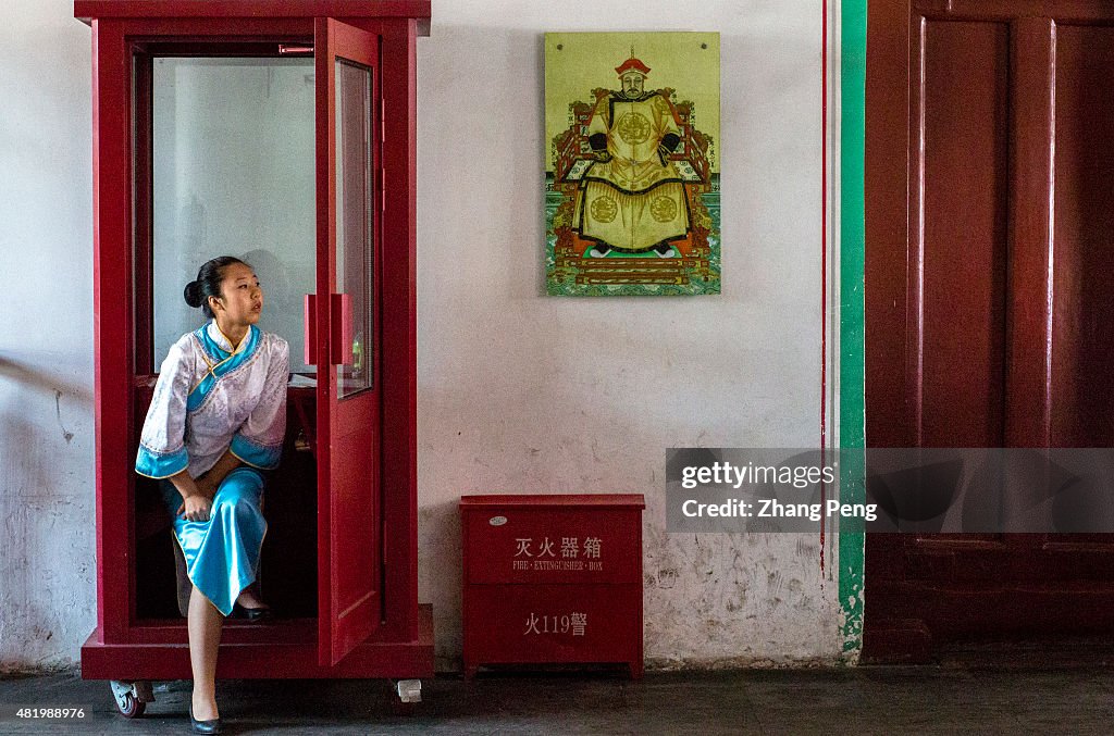 A tour guide wearing traditional Manchurian costume stands...