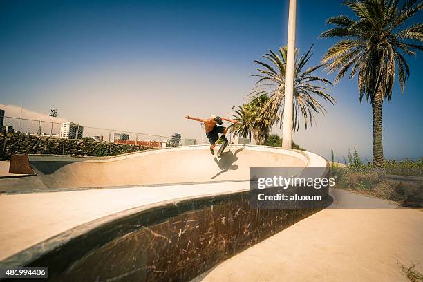 junger mann springen mit skateboard - rampe stock-fotos und bilder
