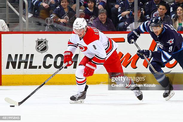 Andrei Loktionov of the Carolina Hurricanes plays the puck up the ice as Evander Kane of the Winnipeg Jets gives chase during first period action at...