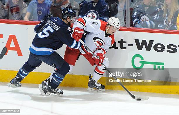 Andrei Loktionov of the Carolina Hurricanes plays the puck along the boards as Matt Halischuk of the Winnipeg Jets defends during second period...