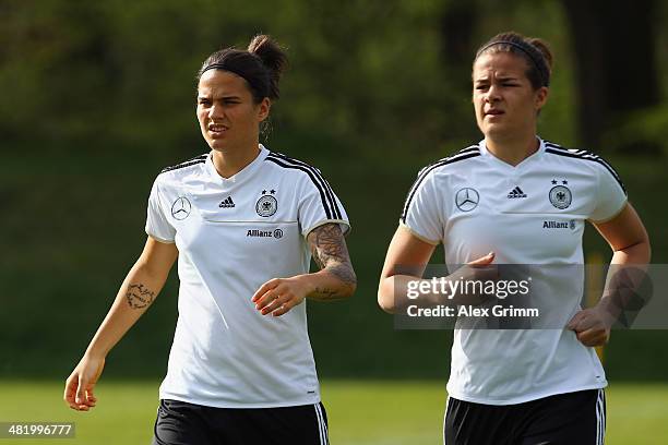 Dsenifer Marozsan and and Lena Lotzen run during a Germany Women's training session at the Commerzbank Arena training ground on April 2, 2014 in...