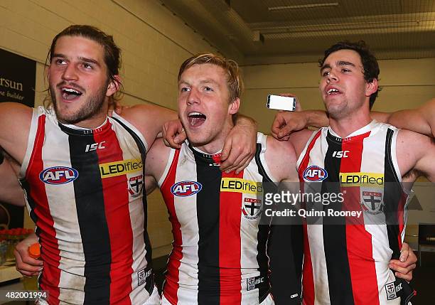 Josh Bruce, Hugh Goddard and Paddy McCartin of the Saints sing the song in the rooms after winning the round 17 AFL match between the Melbourne...