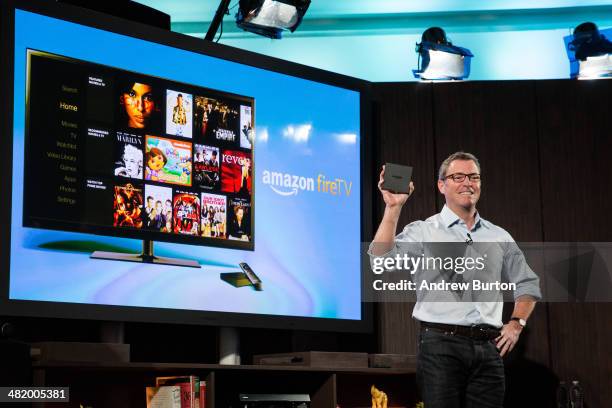 Amazon's vice president of Kindle, Peter Larsen, displays the Amazon Fire TV, a new device that allows users to stream video, music, photos, games...