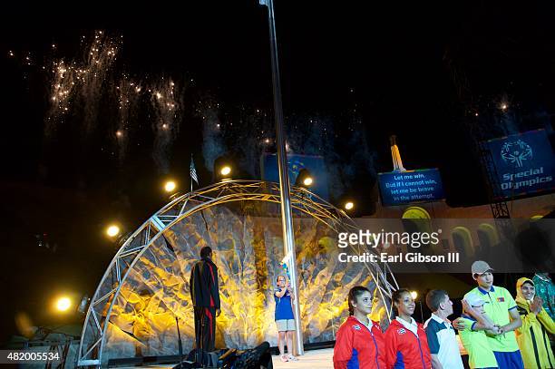 Former Decathlete/Actor Rafer Johnson receives the Flame Of Hope from Destiny Sanchez at the Opening Ceremony Of The Special Olympics World Games Los...