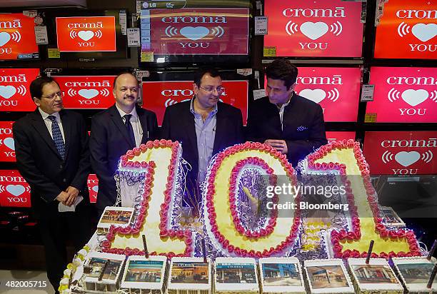 Cyrus Mistry, chairman of Tata Group, second right, and Ajit Joshi, chief executive officer of Infiniti Retail Ltd., second left, stand behind a...