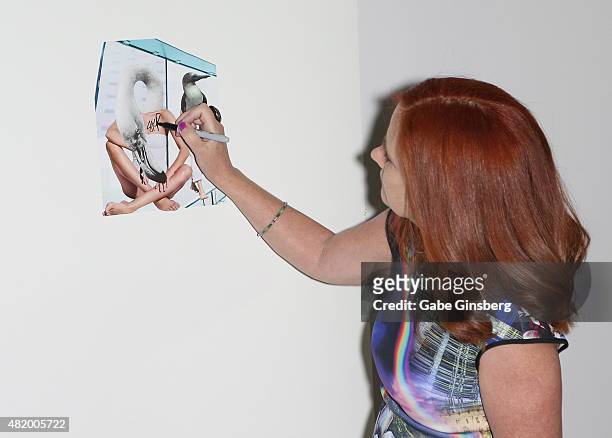 Artist J.K. Russ works on a collage during Vegas Magazine's "Art Of The City" issue celebration at The Cosmopolitan of Las Vegas on July 25, 2015 in...