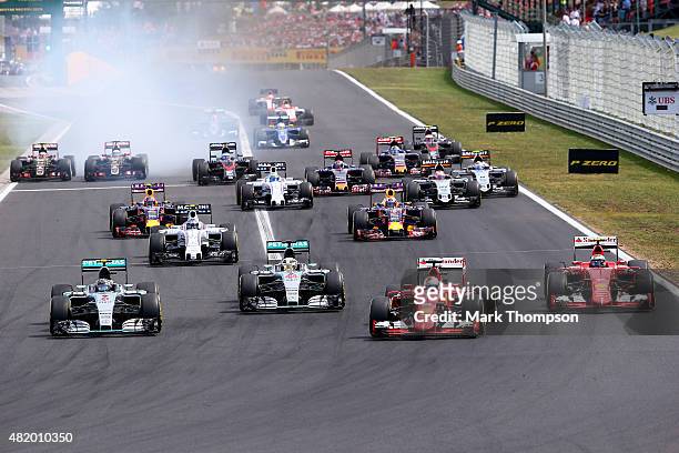 Sebastian Vettel of Germany and Ferrari leads Nico Rosberg of Germany and Mercedes GP, Lewis Hamilton of Great Britain and Mercedes GP and Kimi...