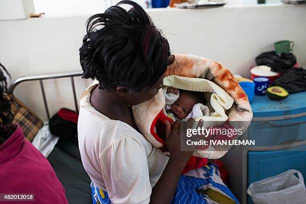 Lucia Kagotha holds her new born baby boy, named 'Obama' in honour of the US President Barack Obama, at the Mbagathi Hospital of Nairobi on July 26,...