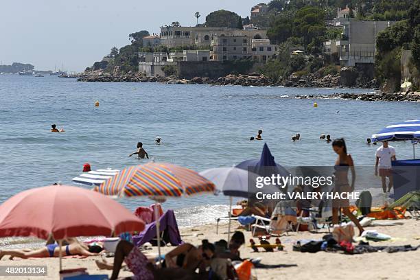 People enjoy a day out at the beach near the villa of the Saudi king in Vallauris Golfe-Juan, southeastern France, on July 26, 2015. King Salman of...