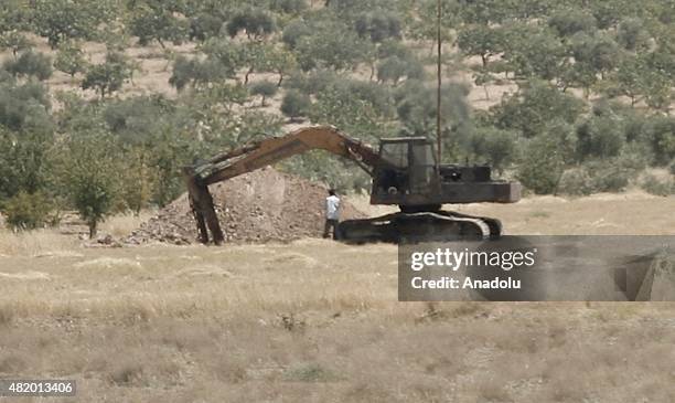 Picture taken from Turkey's Gaziantep province, which has border with Jarabulus district of Syria's Aleppo province, shows Daesh militants walk and...