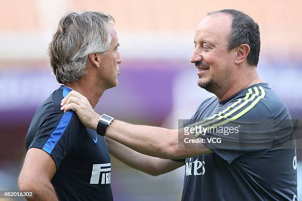 Rafael Benitez , head coach of Real Madrid, speaks with Roberto Mancini, head coach of Inter Milan, prior to a training session at Tianhe Sports...