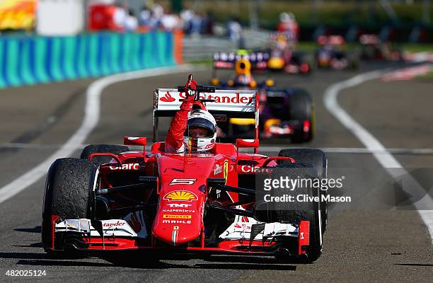 Sebastian Vettel of Germany and Ferrari celebrates as he approaches Parc Ferme after winning the Formula One Grand Prix of Hungary at Hungaroring on...