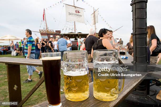 Beer festival in the Bonn Rheinaue leisure park. Filled beer glasses on a table.