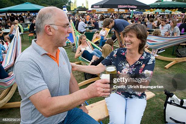 Beer festival in the Bonn Rheinaue leisure park. Toasting with filled beer glasses.