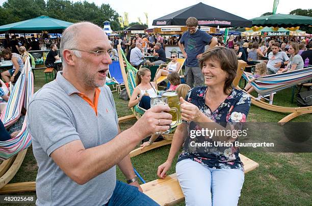 Beer festival in the Bonn Rheinaue leisure park. Toasting with filled beer glasses.