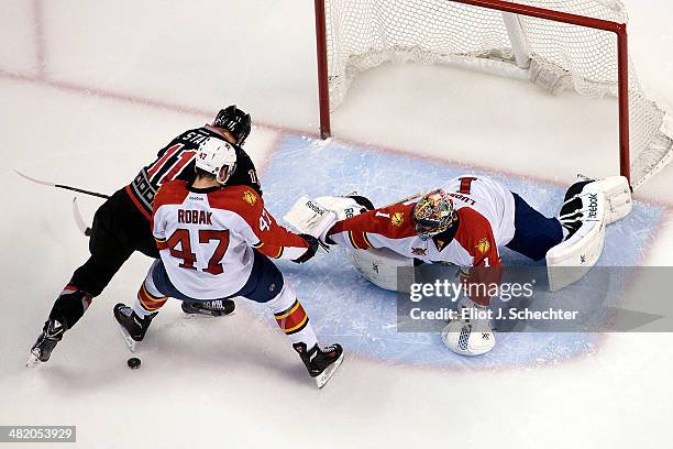 Goaltender Roberto Luongo of the Florida Panthers defends the net with the help of teammate Colby Robak against Jordan Staal of the Carolina...