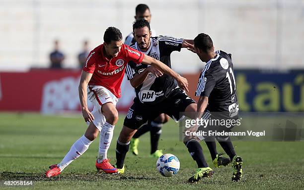 Biro Biro and Thiago Alves of Ponte Preta fights for the ball with Nilmar of Internacional during the match between Ponte Preta and Internacional for...