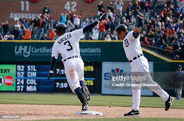 Ian Kinsler of the Detroit Tigers celebrates his 10th inning game winning RBI single with first base coach Omar Vizquel to beat the Kansas City...