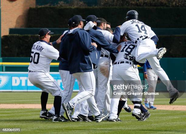 Austin Jackson of the Detroit Tigers jumps on teammates after Ian Kinsler drove him in with a 10th inning RBI single to beat the Kansas City Royals...
