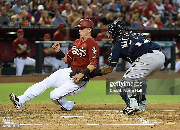 Jake Lamb of the Arizona Diamondbacks is tagged out at home plate by Martin Maldonado of the Milwaukee Brewers during the second inning at Chase...